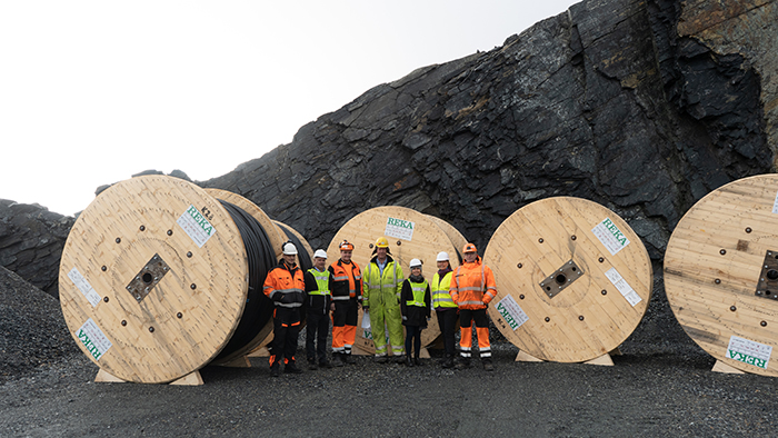 People standing in front of the cable drums