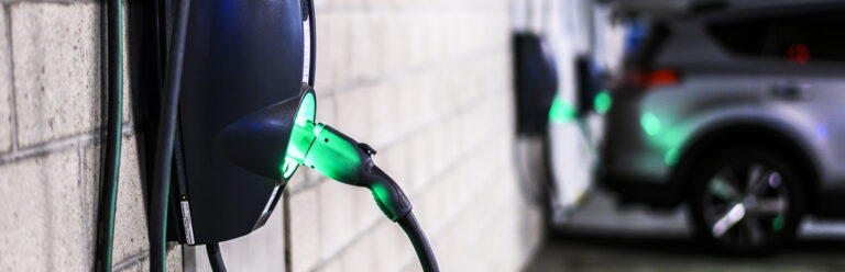 Power supply box in an electric vehicle charging station parking lot in a public garage.